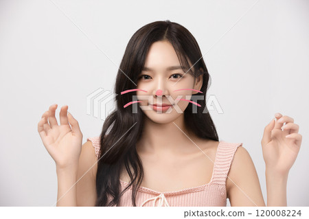 Woman in her 20s drawing cat whiskers and striking a cute pose Woman in her 20s drawing cat whiskers and striking a cute pose 120008224