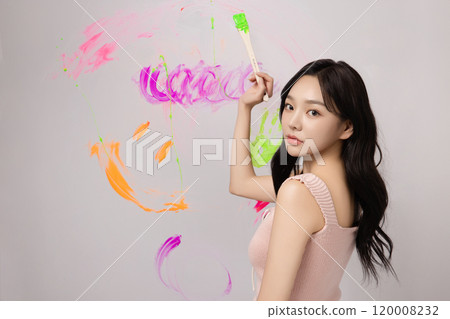 A woman in her 20s who drew colorful graffiti on the wall with paint 120008232