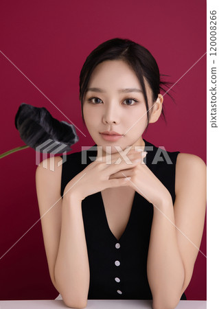 A woman in her 20s posing in front of black poppy flowers 120008266
