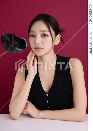 A woman in her 20s posing in front of black poppy flowers A woman in her 20s posing in front of black poppy flowers 120008269