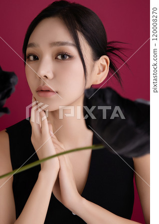 A woman in her 20s posing in front of black poppy flowers A woman in her 20s posing in front of black poppy flowers 120008270