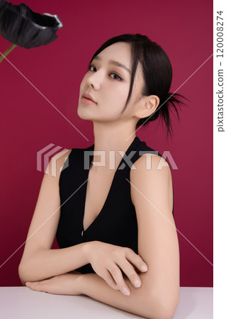 A woman in her 20s posing in front of black poppy flowers A woman in her 20s posing in front of black poppy flowers 120008274