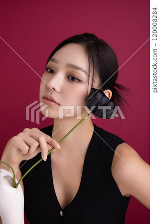 A woman in her 20s posing in front of black poppy flowers 120008284