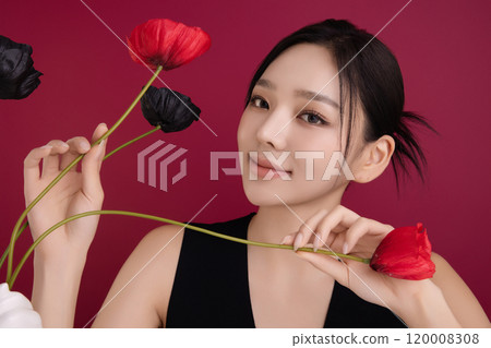 A woman in her 20s showing an elegant pose using poppy flowers 120008308