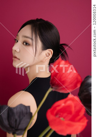A woman in her 20s showing an elegant pose using poppy flowers 120008314