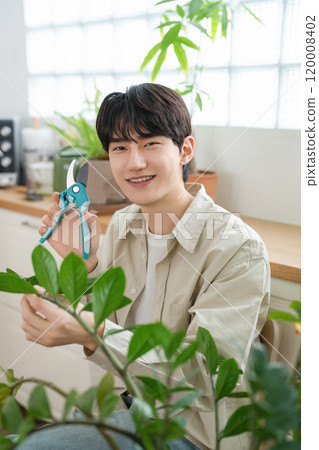 A man in his 20s with a hobby of growing plants A man in his 20s with a hobby of growing plants 120008402
