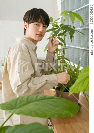 A man in his 20s with a hobby of growing plants A man in his 20s with a hobby of growing plants 120008425