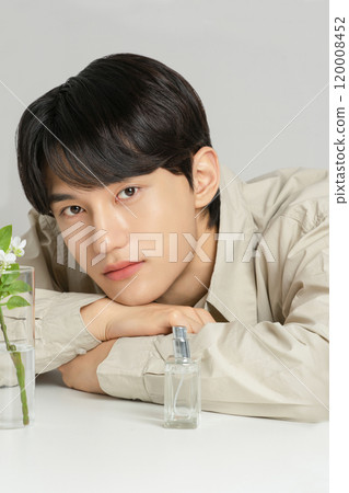 A man in his 20s posing with a perfume bottle A man in his 20s posing with a perfume bottle 120008452