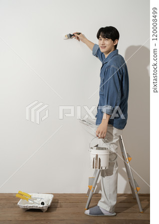 A man in his 20s painting a wall A man in his 20s painting a wall 120008499