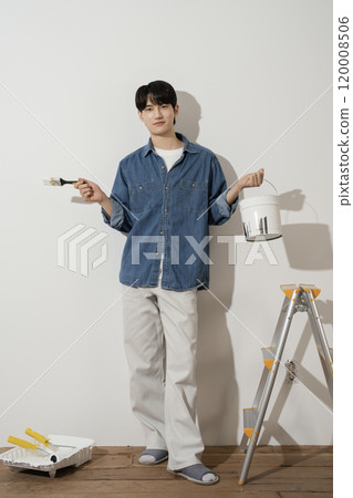 A man in his 20s painting a wall 120008506