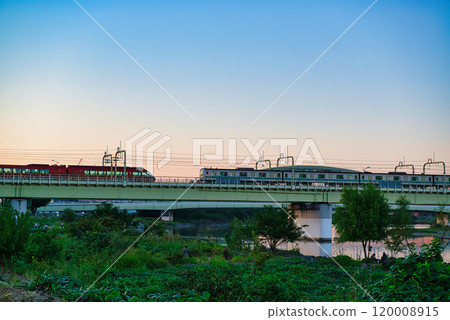 Noborito: Odakyu Line trains shining in the setting sun as seen from the Tama River bank Noborito: Odakyu Line trains shining in the setting sun as seen from the Tama River bank 120008915