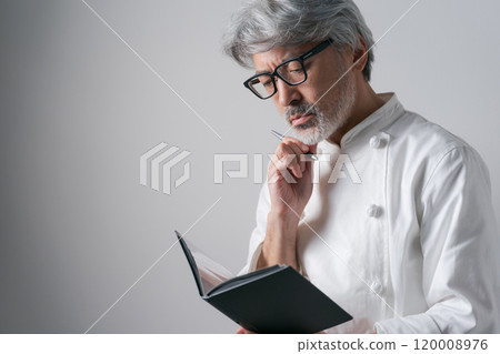 Male chef looking at documents Male chef looking at documents 120008976