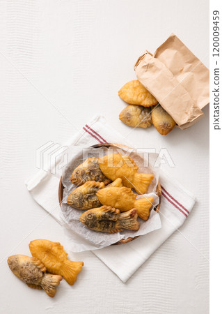 Bungeoppang spilling out of a paper bag and on a plate Bungeoppang spilling out of a paper bag and on a plate 120009459