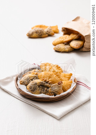 Bungeoppang spilling out of a paper bag and on a plate Bungeoppang spilling out of a paper bag and on a plate 120009461