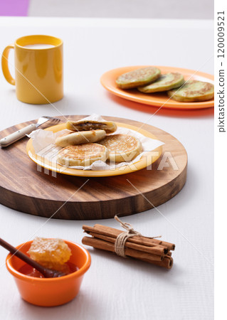 Hotteok, milk and honey plated on a wooden tray Hotteok, milk and honey plated on a wooden tray 120009521
