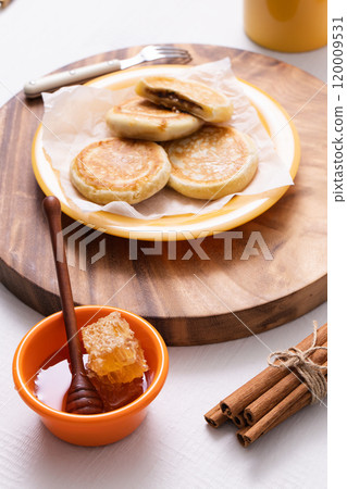 Hotteok, milk and honey plated on a wooden tray 120009531