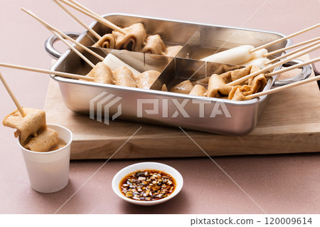 Fish cake machine placed on a cutting board filled with oden Fish cake machine placed on a cutting board filled with oden 120009614