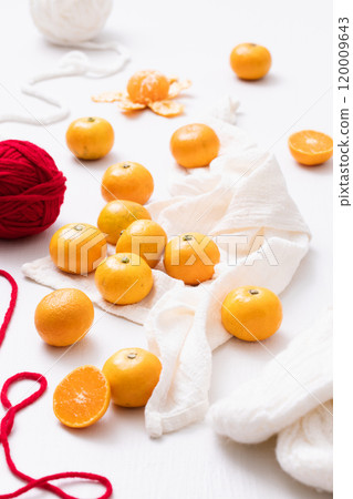 Wool, fur gloves and fresh tangerines scattered around Wool, fur gloves and fresh tangerines scattered around 120009643