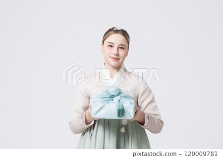 Western woman wearing Hanbok and holding a gift wrapped in Korean style 120009781