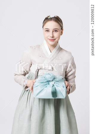 Western woman wearing Hanbok and holding a gift wrapped in Korean style 120009812