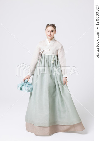 Western woman wearing Hanbok and holding a gift wrapped in Korean style 120009827