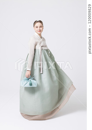 Western woman wearing Hanbok and holding a gift wrapped in Korean style 120009829