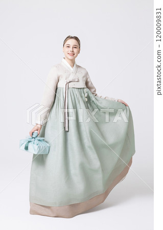 Western woman wearing Hanbok and holding a gift wrapped in Korean style 120009831