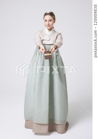 A foreign woman wearing traditional Korean hanbok holding a holiday gift 120009838