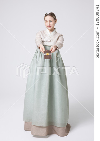 A foreign woman wearing traditional Korean hanbok holding a holiday gift 120009841