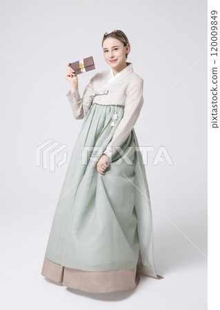 A foreign woman wearing traditional Korean hanbok holding a holiday gift 120009849