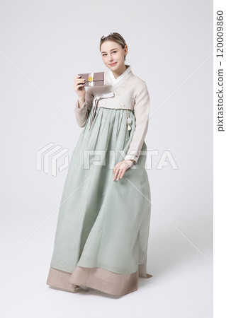 A foreign woman wearing traditional Korean hanbok holding a holiday gift 120009860