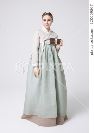 A foreign woman wearing traditional Korean hanbok holding a holiday gift 120009867