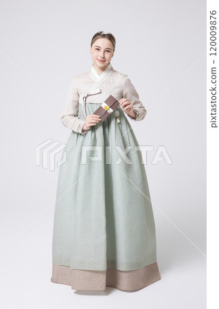 A foreign woman wearing traditional Korean hanbok holding a holiday gift 120009876