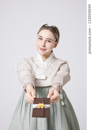 A foreign woman wearing traditional Korean hanbok holding a holiday gift 120009894