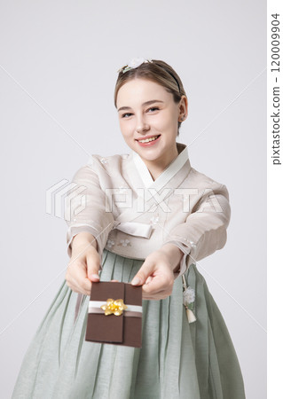 A foreign woman wearing traditional Korean hanbok holding a holiday gift 120009904