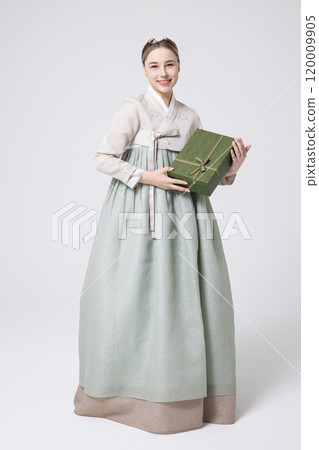 A foreign woman wearing traditional Korean hanbok holding a holiday gift 120009905