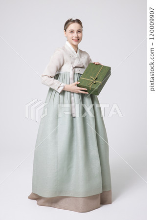 A foreign woman wearing traditional Korean hanbok holding a holiday gift 120009907