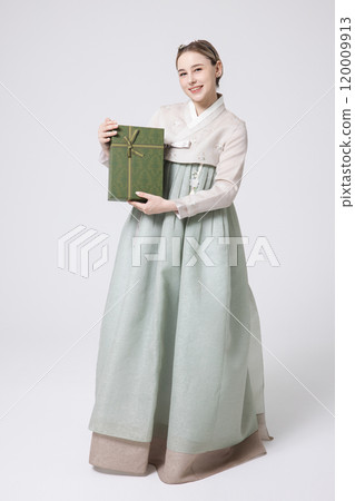 A foreign woman wearing traditional Korean hanbok holding a holiday gift 120009913