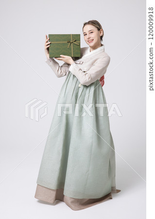 A foreign woman wearing traditional Korean hanbok holding a holiday gift A foreign woman wearing traditional Korean hanbok holding a holiday gift 120009918