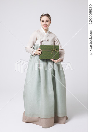A foreign woman wearing traditional Korean hanbok holding a holiday gift A foreign woman wearing traditional Korean hanbok holding a holiday gift 120009920