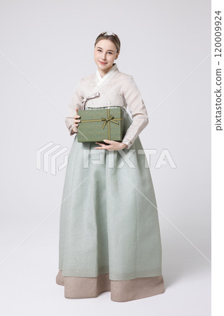 A foreign woman wearing traditional Korean hanbok holding a holiday gift 120009924