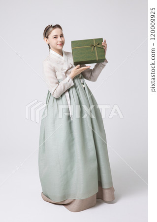 A foreign woman wearing traditional Korean hanbok holding a holiday gift 120009925