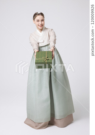 A foreign woman wearing traditional Korean hanbok holding a holiday gift A foreign woman wearing traditional Korean hanbok holding a holiday gift 120009926