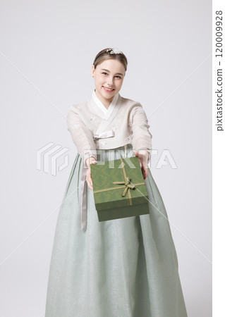 A foreign woman wearing traditional Korean hanbok holding a holiday gift 120009928