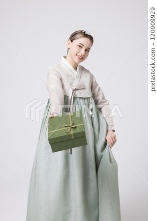 A foreign woman wearing traditional Korean hanbok holding a holiday gift 120009929