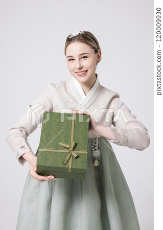 A foreign woman wearing traditional Korean hanbok holding a holiday gift 120009930