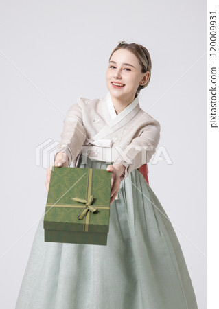 A foreign woman wearing traditional Korean hanbok holding a holiday gift 120009931