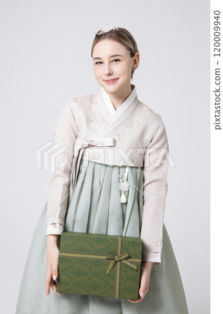 A foreign woman wearing traditional Korean hanbok holding a holiday gift A foreign woman wearing traditional Korean hanbok holding a holiday gift 120009940