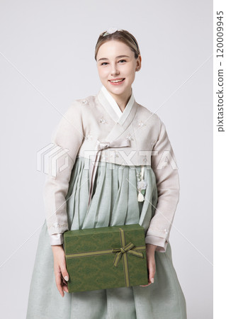 A foreign woman wearing traditional Korean hanbok holding a holiday gift A foreign woman wearing traditional Korean hanbok holding a holiday gift 120009945
