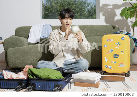 A man in his 20s preparing for a trip A man in his 20s preparing for a trip 120010008